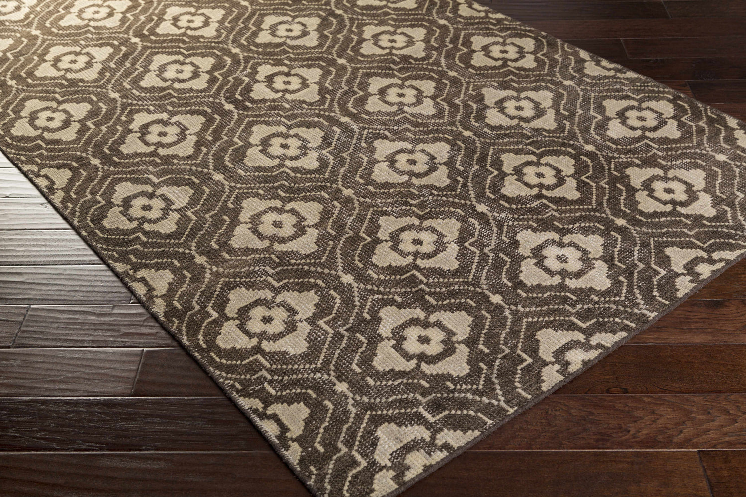 Close-up of the Claysville Area Rug, a beige and dark brown wool rug with a floral geometric pattern. Corner