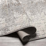 Close-up of the charcoal and gray Calabasa Area Rug showing the contemporary pattern and machine woven texture. Fold
