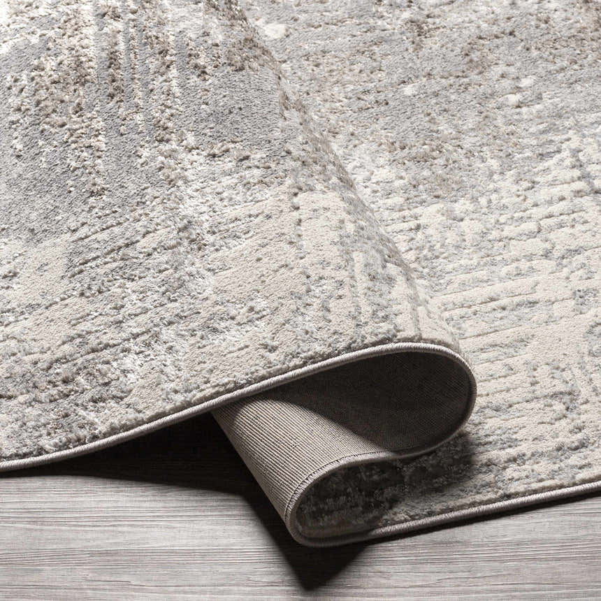Close-up of the charcoal and gray Calabasa Area Rug showing the contemporary pattern and machine woven texture. Fold