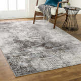 Living room scene with a charcoal and gray Calabasa Area Rug, wood chair, and modern side table. Roomscene-Rectangle