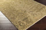 Close-up of the Cleburne Area Rug showing its light brown, olive, and tan colors and hand-knotted traditional design. Corner