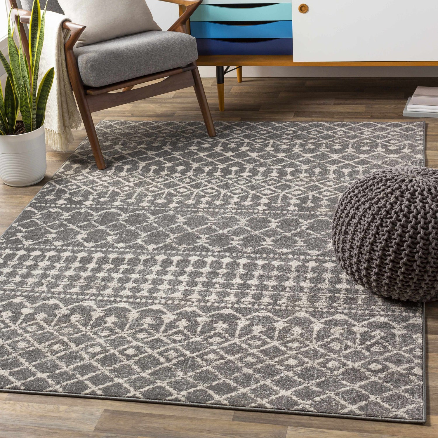 Living room scene with gray Cliffwood Area Rug, chair, pouf, and mid-century modern cabinet. Roomscene-Rectangle