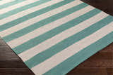 Close-up of the hand woven Clio Clearance Rug. Aqua and cream stripes on dark wood floor. Corner