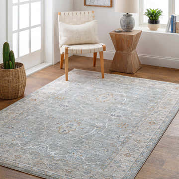 Light-filled room with a Clem Boutique Area Rug in cream, lavender, and blue. Farmhouse style with chair, side table, and wood floors. Roomscene-Rectangle