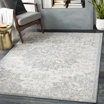 Living room scene with a gray Colonie Area Rug, gray chair, and gold side table. Roomscene-Rectangle