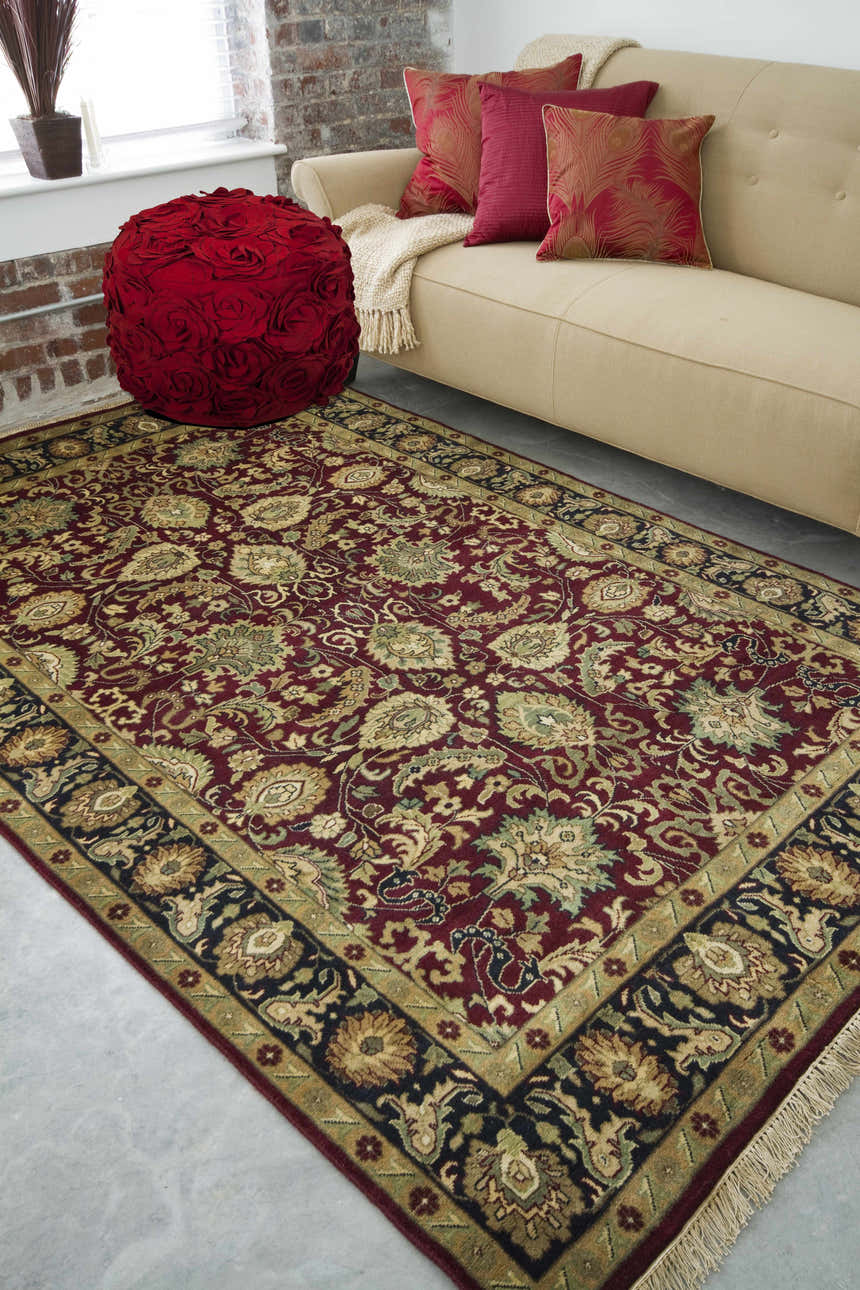Living room scene with a Coalinga Premium Wool Area Carpet, tan sofa, and red floral ottoman. Roomscene-Rectangle