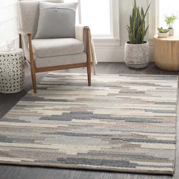 Living room scene with a Clarinda Area Carpet in cream, denim, and gray. Mid-century chair, plants, and modern decor. Roomscene-Rectangle