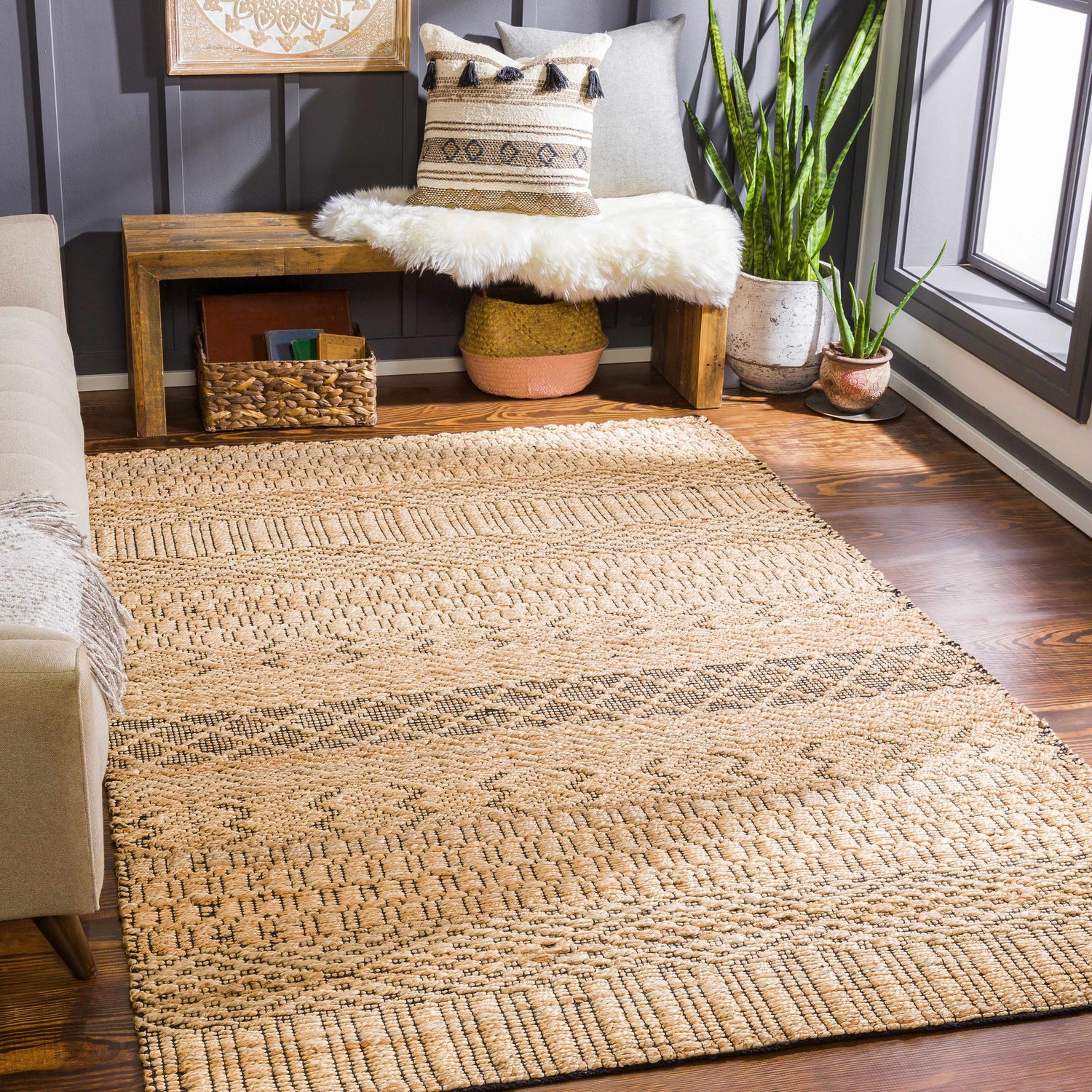 Bohemian living room with tan Cloverly Tribal Jute Carpet, wood bench, plants, and gray accent wall. Roomscene-Rectangle