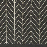Close-up of the Clymer Wool Rug. Black rug with off-white geometric, arrow-like, bohemian pattern. Hand woven texture. Swatch