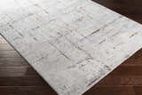 Close-up of a Concordia Faux Silk Rug. Abstract design in off-white, gray, burgundy, burnt orange, and navy on dark wood floors. Corner
