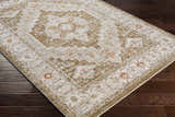Close-up of a Canadensis Thick Luxe Traditional Turkish Rug in light beige, charcoal, and olive on dark wood floors. Corner