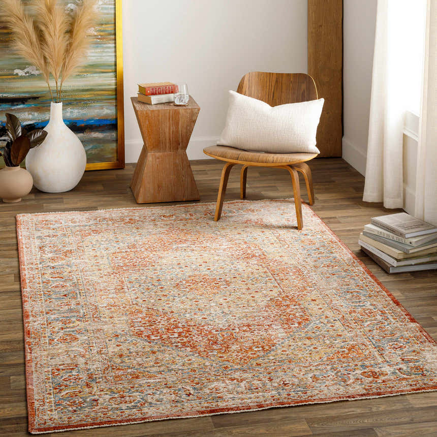 Living room scene with a traditional Candiis Luxe Performance Rug in brick red, cream, and blue. Bohemian style with wood furniture. Roomscene-Rectangle