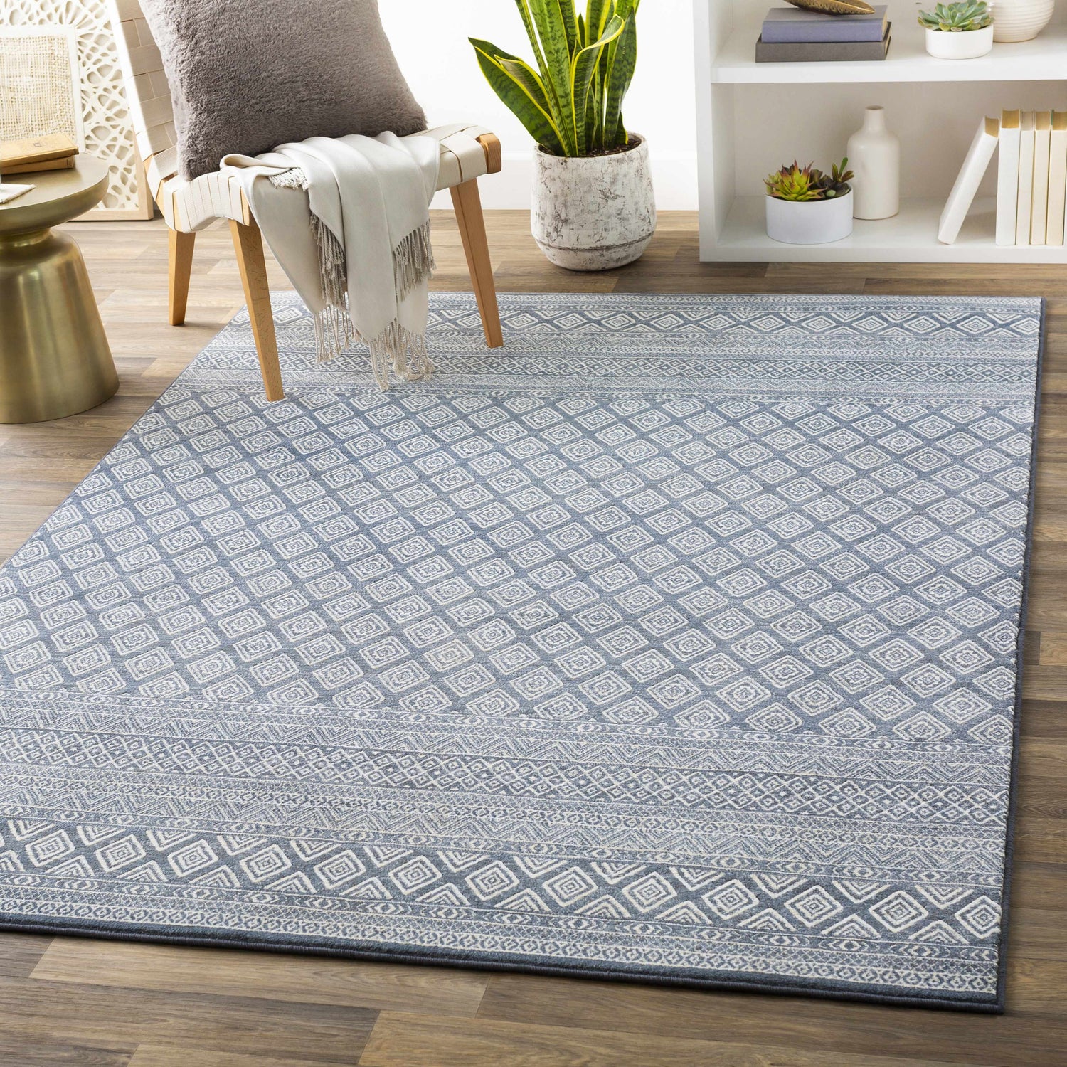 Farmhouse living room with blue and ivory Centertown Area Rug, chair, side table, and bookshelf. Roomscene-Rectangle