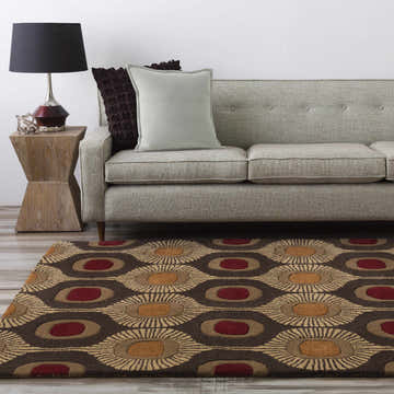 Living room scene with a Canovanas Modern Wool Rug in brown, burgundy, and tan, paired with a gray sofa and wooden side table. Roomscene-Rectangle