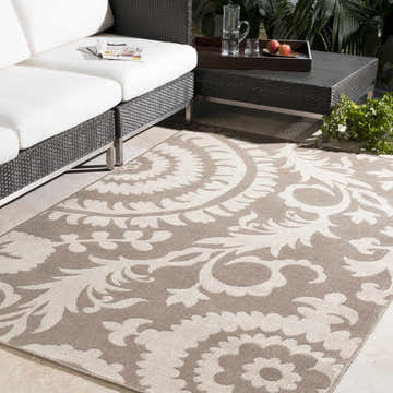 Outdoor patio scene with light beige Collegeport Area Rug, wicker furniture, and neutral tones. Roomscene-Rectangle