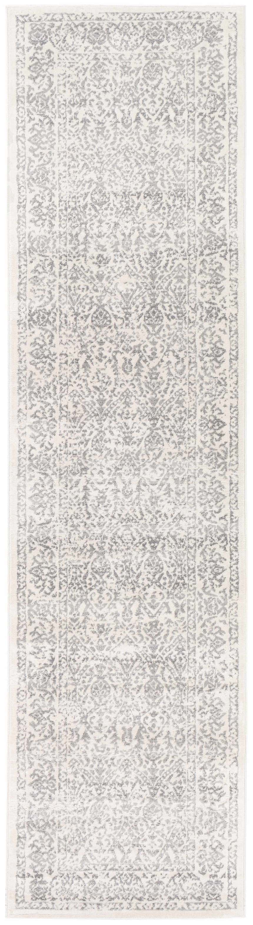 Close-up of the Comstock Area Rug. Bohemian style rug in charcoal, medium gray, off white, and white gray. Machine woven texture. Design-Runner-2710