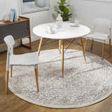 Dining room scene with a round white table and white chairs on a round Comstock Area Rug in charcoal and gray. Roomscene-Round
