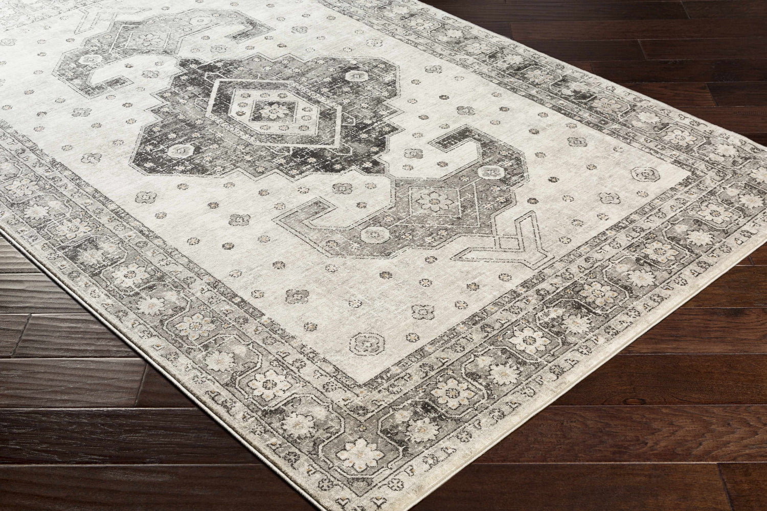 Close-up of the Congress Area Rug: a beige rug with black, charcoal, and gray traditional Southwestern patterns. Corner