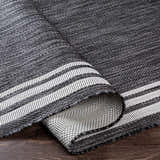 Close-up of the charcoal and cream Coonamble Bordered Antrasit Rug showing its woven texture and striped border. Fold