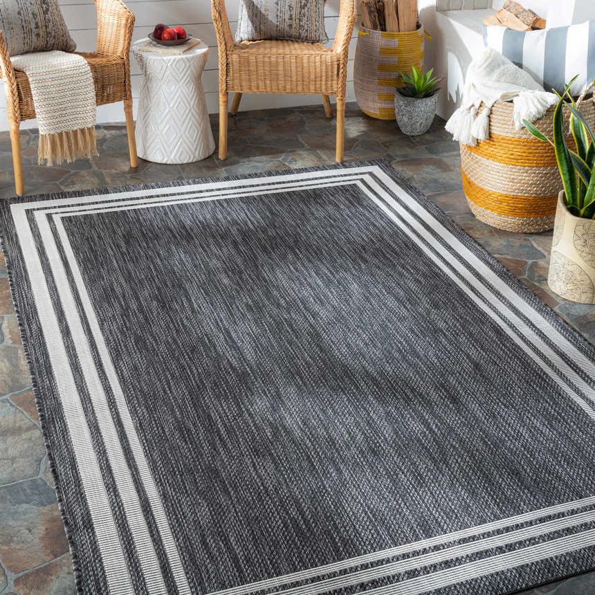 Cozy porch scene with a charcoal Coonamble Bordered Antrasit Rug, wicker chairs, and natural textures. Roomscene-Rectangle