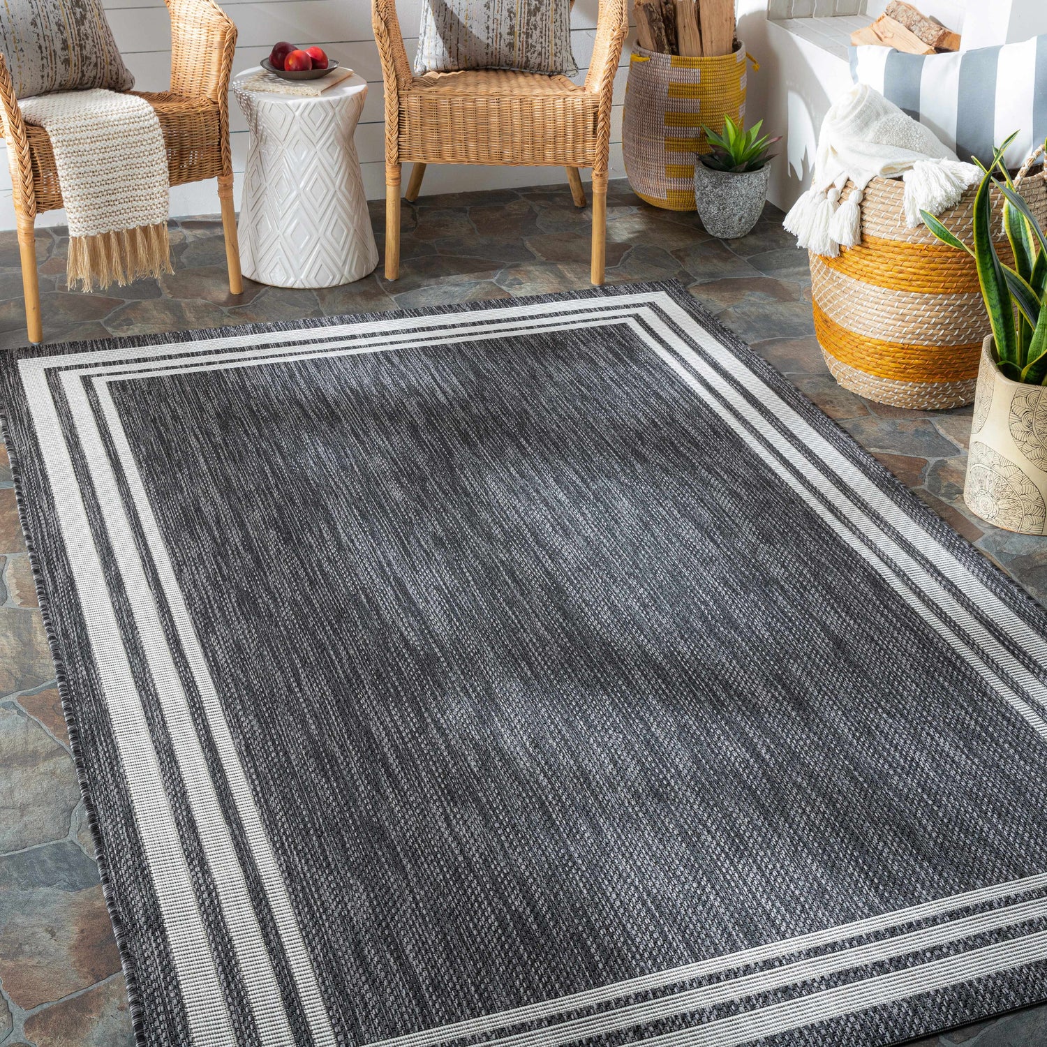 Cozy porch scene with a charcoal Coonamble Bordered Antrasit Rug, wicker chairs, and natural textures. Roomscene-Rectangle