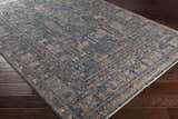 Close-up of the Mirabel Denim Blue Traditional Rug, showing its cream, blue, brown, and mustard intricate pattern and soft texture. Corner