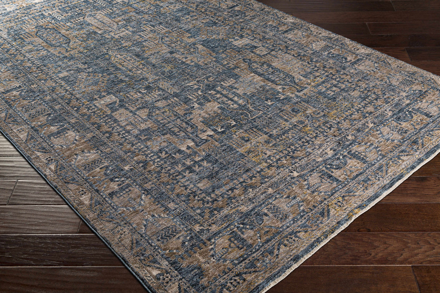 Close-up of the Mirabel Denim Blue Traditional Rug, showing its cream, blue, brown, and mustard intricate pattern and soft texture. Corner