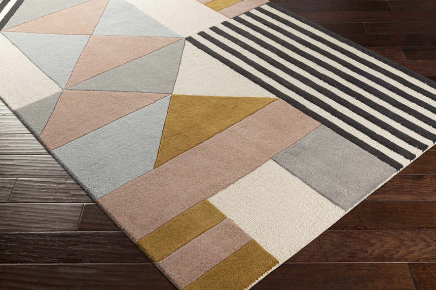 Close-up of the Coorparoo wool area rug. Geometric design in beige, black stripes, dusty pink, gray, and mustard. Hand-tufted texture. Corner