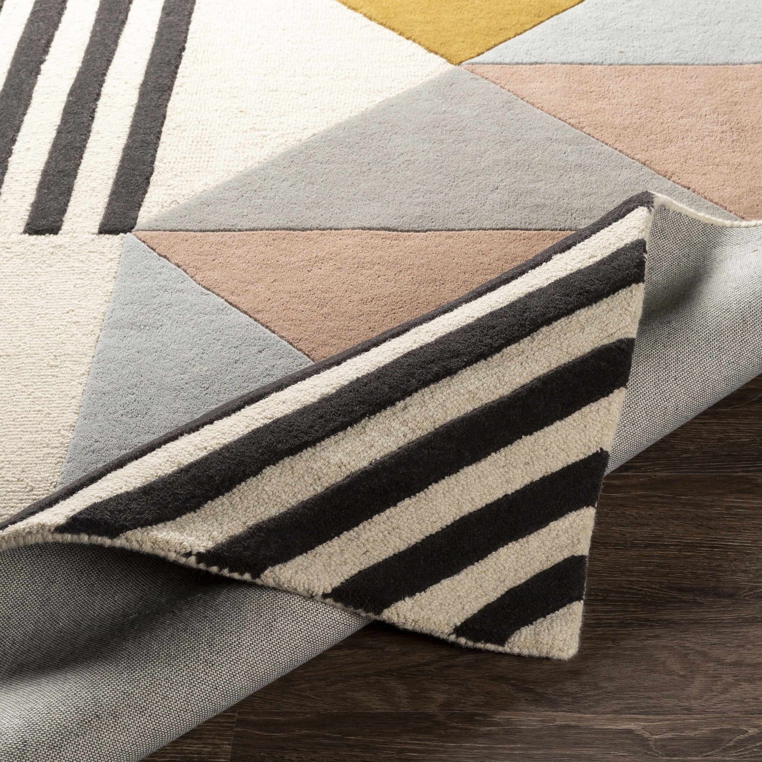 Close-up of the Coorparoo wool area rug showing its geometric design, beige, black, dusty pink, and gray colors. Fold