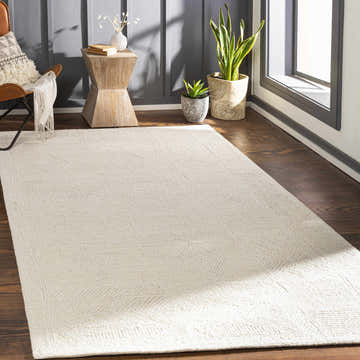 Living room scene with a cream Cork Textured Wool Rug, leather chair, wood side table, and plants. Roomscene-Rectangle