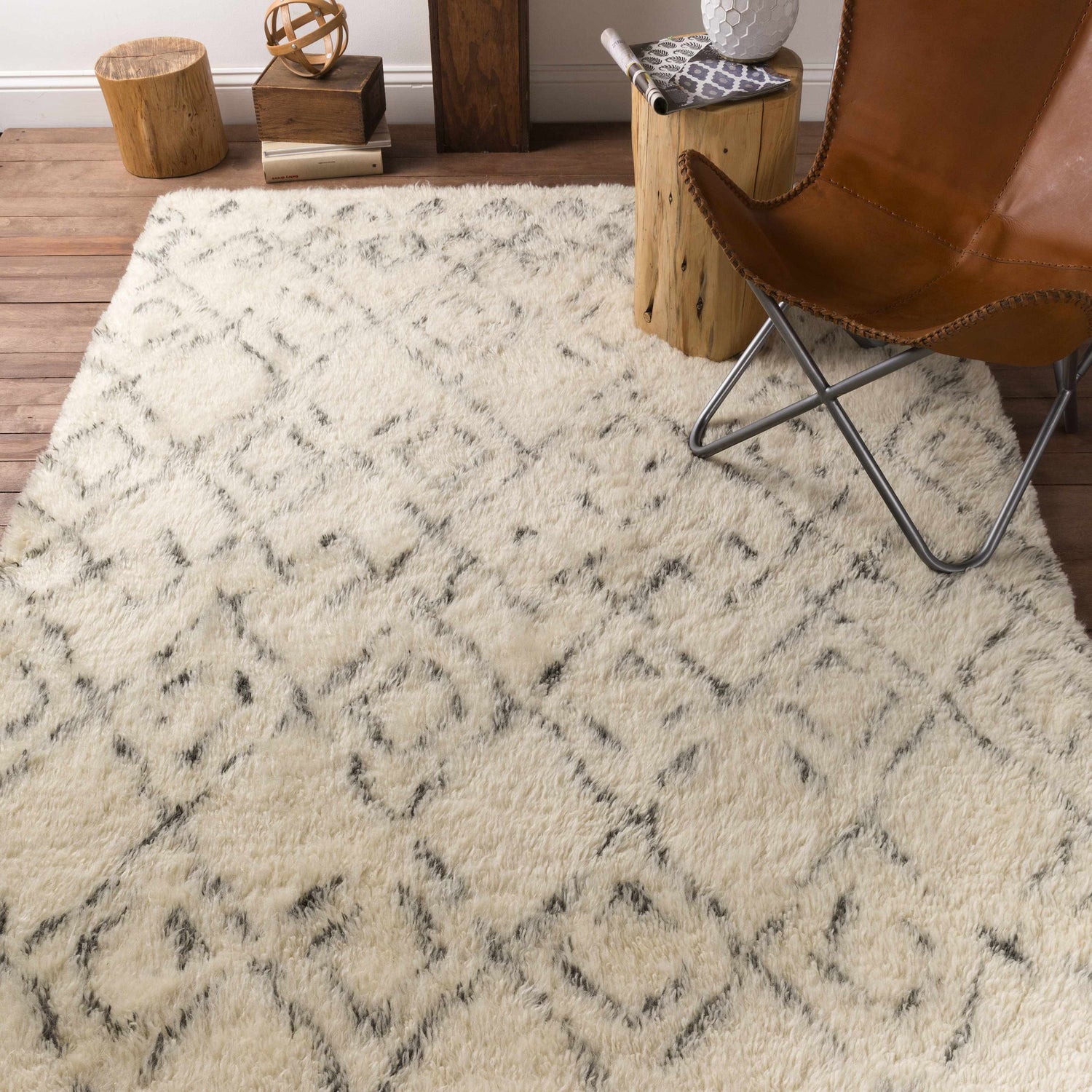 Living room scene with a cream shag Cotgrave rug, leather chair, and rustic wood accents. Styleshot