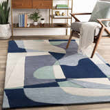 Living room scene with a Crawfordsville Modern hand-tufted wool rug in dark blue, gray, and sage tones. Mid-century modern style. Roomscene-Rectangle