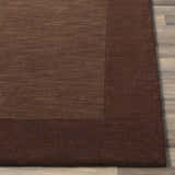 Close-up of a Bordered Solid Brown Wool Rug showing the texture and color variations. Front