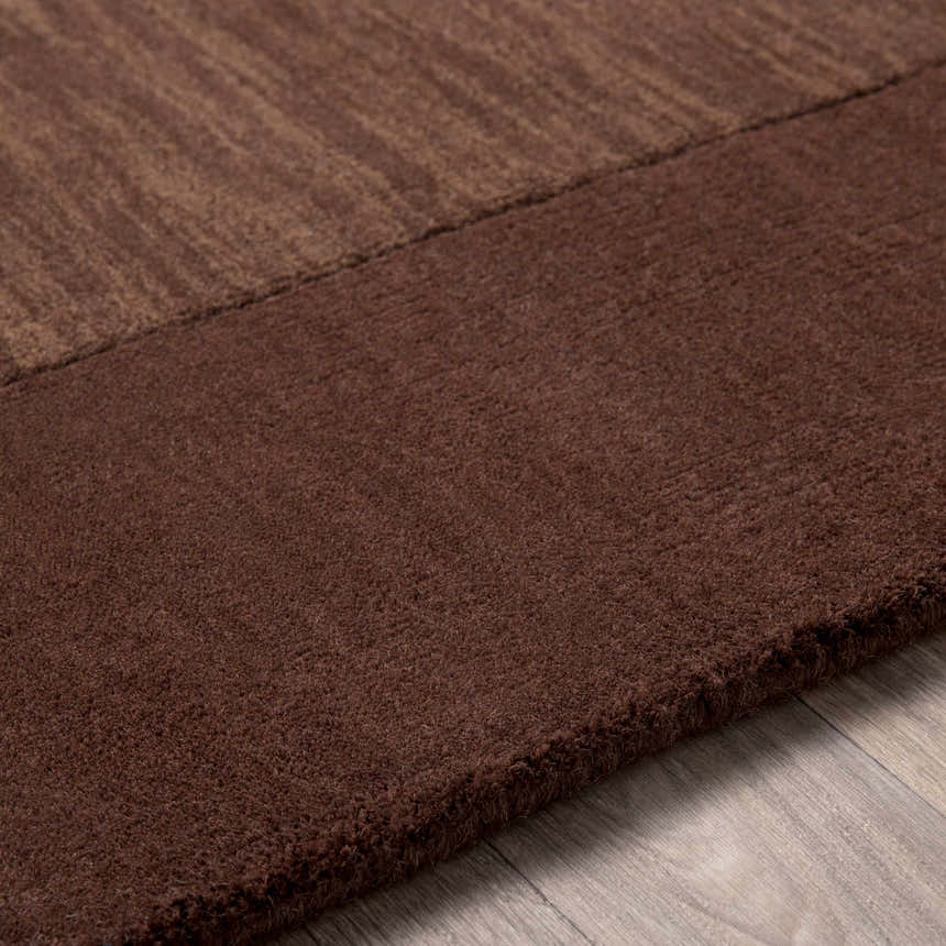 Close up of the dark brown Bordered Solid Brown Wool Rug showing texture and border detail. Texture