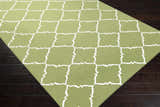 Close-up of Creekside Area Rug showing the green and white geometric trellis pattern and hand woven wool texture. Corner