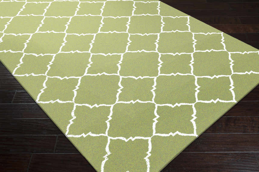 Close-up of Creekside Area Rug showing the green and white geometric trellis pattern and hand woven wool texture. Corner