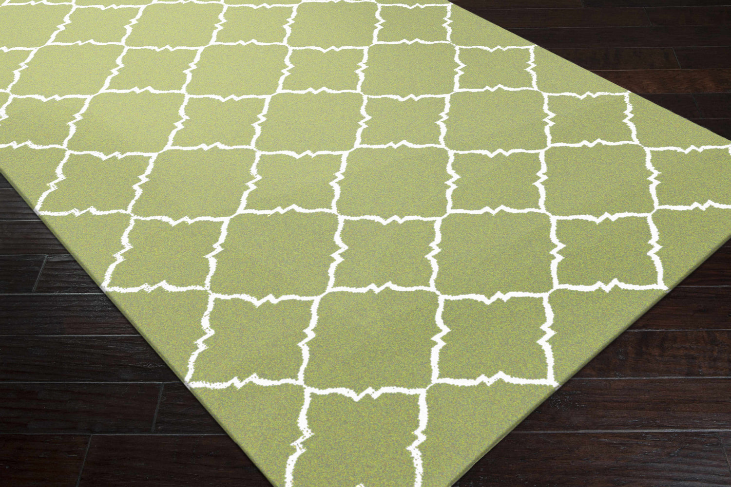 Close-up of Creekside Area Rug showing the green and white geometric trellis pattern and hand woven wool texture. Corner