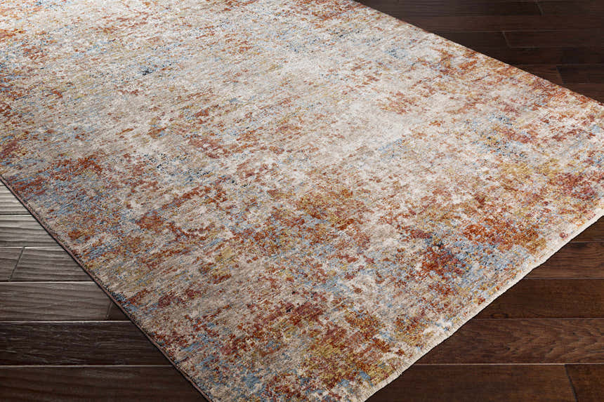 Close-up of the Cranfield Area Rug showing its cream, brick red, and light blue contemporary design on a dark wood floor. Corner