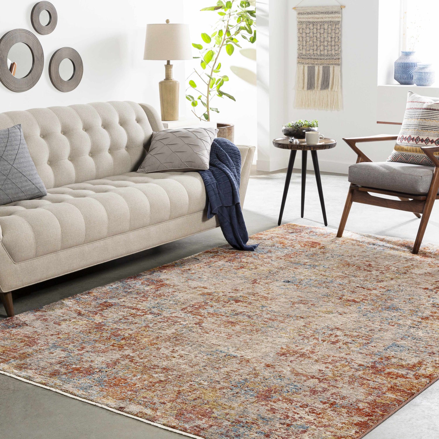 Living room scene with a neutral sofa and the Cranfield Area Rug in brick red, cream, and blue tones. Roomscene-Rectangle