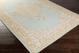 Close-up of the Carpio Carpet: a hand-knotted wool rug in beige, light brown, sage, and gray with a traditional farmhouse design. Corner
