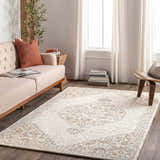 Living room scene with a neutral sofa and the Currimao Area Carpet, a traditional rug with a faded Persian-style design. Roomscene-Rectangle