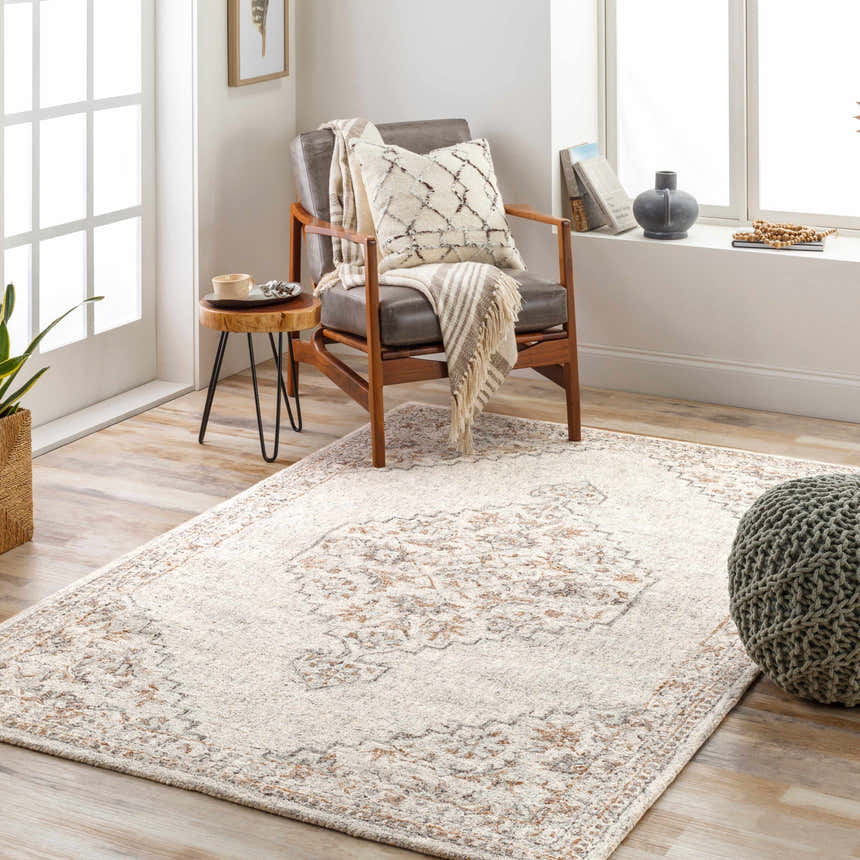 Living room scene with a Currimao Area Carpet, a gray armchair, and a green pouf, creating a cozy and inviting space. Roomscene-Rectangle