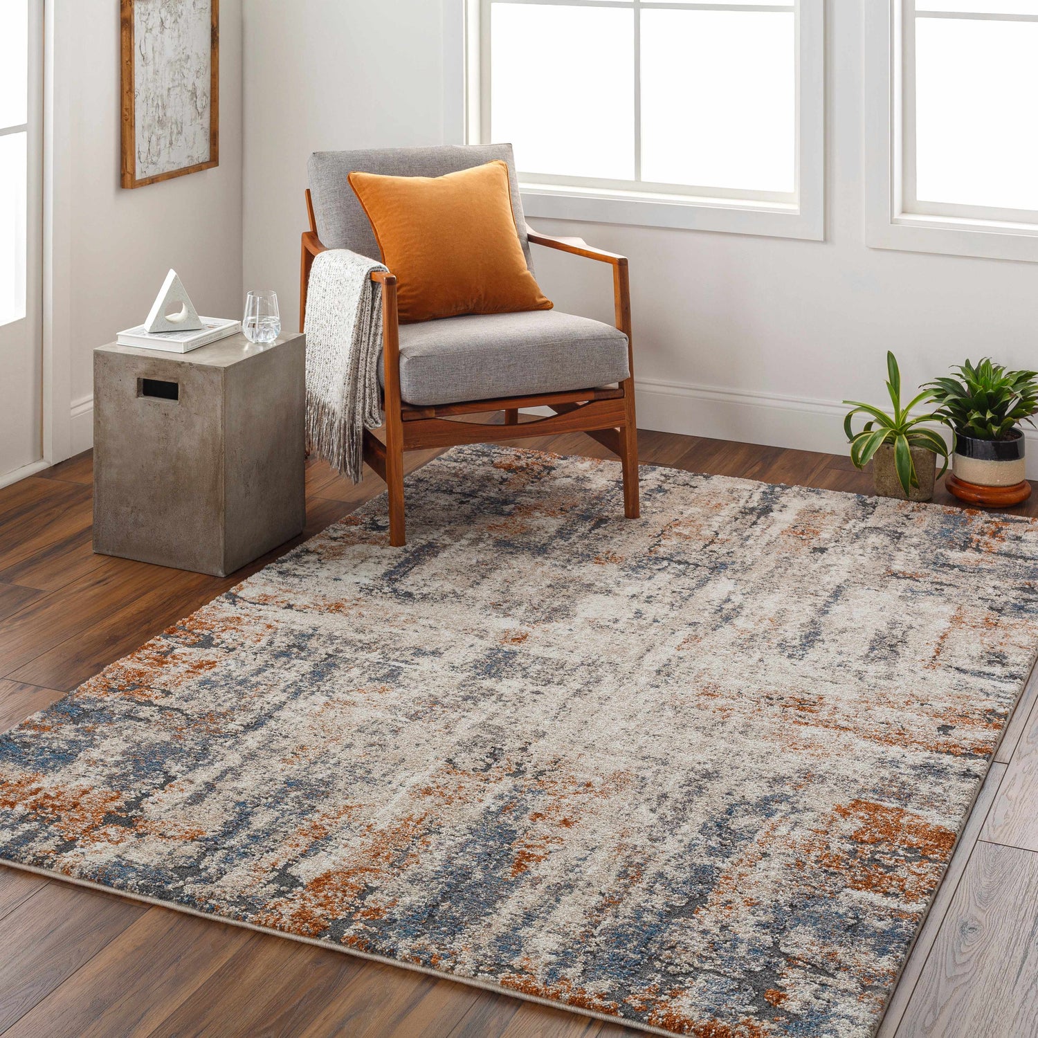 Living room scene with a Cashi Thick Luxe Rug in clay, dark brown, mocha, and off white. Mid-century chair and concrete side table. Roomscene-Rectangle