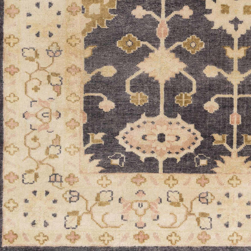 Close up of the hand-knotted Castlewood Area Rug. Traditional floral pattern in black, burnt orange, and light olive. Swatch