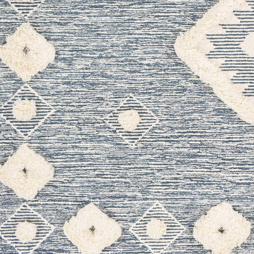 Close-up of Curllsville Area Rug. Cream wool tufted diamonds on a textured navy blue and white striped background. Swatch