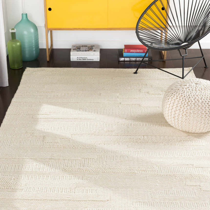 Contemporary kitchen scene with a cream Cypress Textured Wool Rug, yellow cabinet, black chair, and knitted pouf. Roomscene-Rectangle
