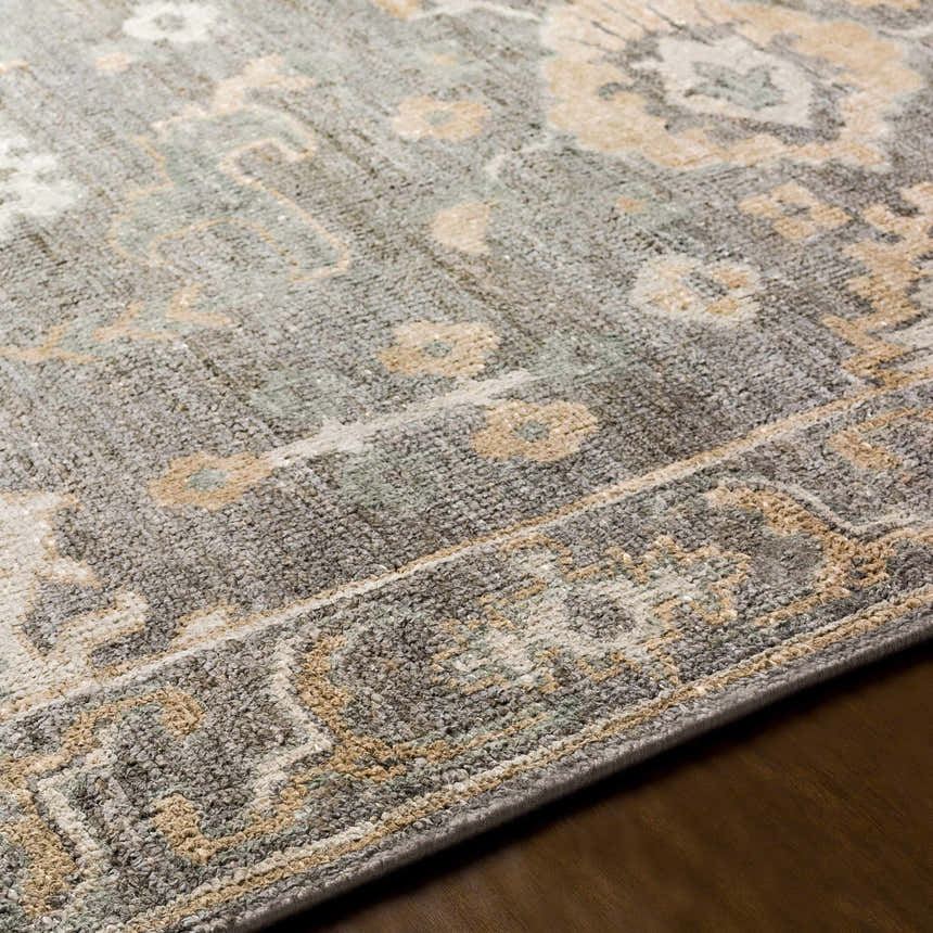 Close-up of the hand-knotted Dallas Area Rug. Features charcoal, dusty sage, gray, and tan colors with a traditional pattern. Texture