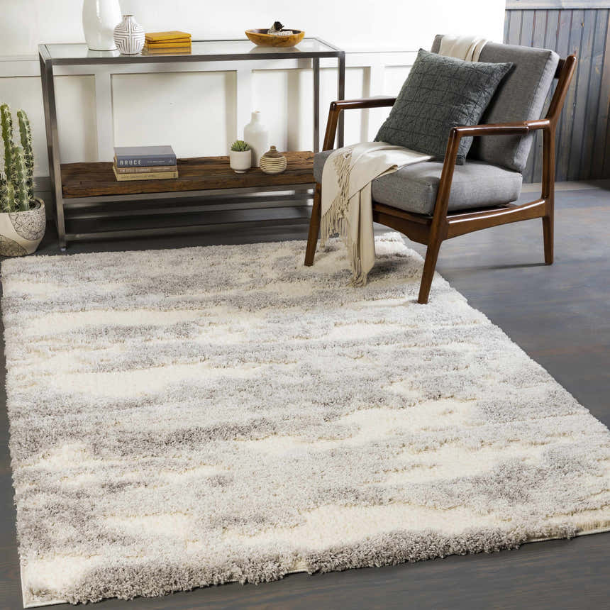 Living room scene with a gray chair and a soft, gray and white Dagami Area Rug. Roomscene-Rectangle