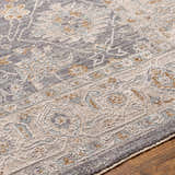 Close-up of the Dalupirip rug showing its traditional, vintage pattern in brown, gray, and light beige tones. Luxe, thick texture. Texture