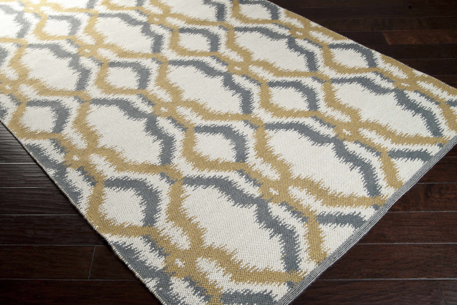 Close-up of the hand woven Danvers Area Rug. Charcoal, ivory, and mustard interlocking pattern on a wool rug. Corner